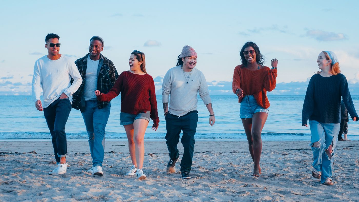 Group of friends walking together on a beach holiday