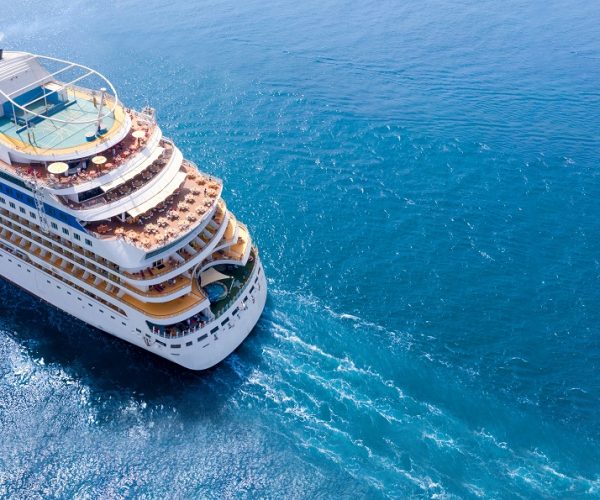 Aerial view of beautiful white cruise ship above luxury cruise close up at stern of cruise sail with contrail in the ocean sea  concept tourism travel on holiday take a vacation time on summer.